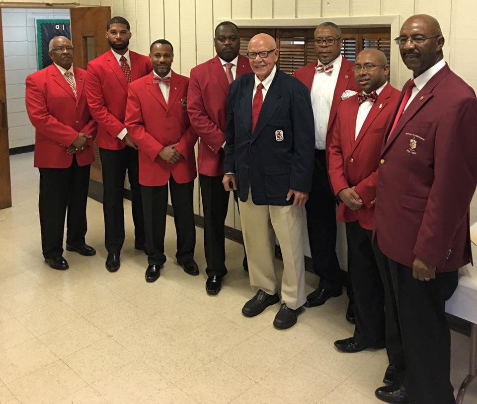 Brothers in red blazers with guest at chapter function