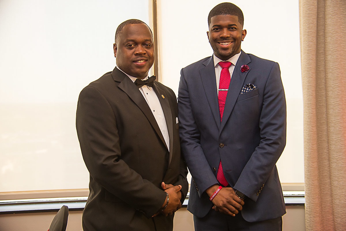 Two brothers in formal attire posing together at gala