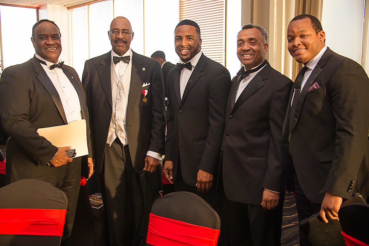 Five brothers in formal attire posing together at gala