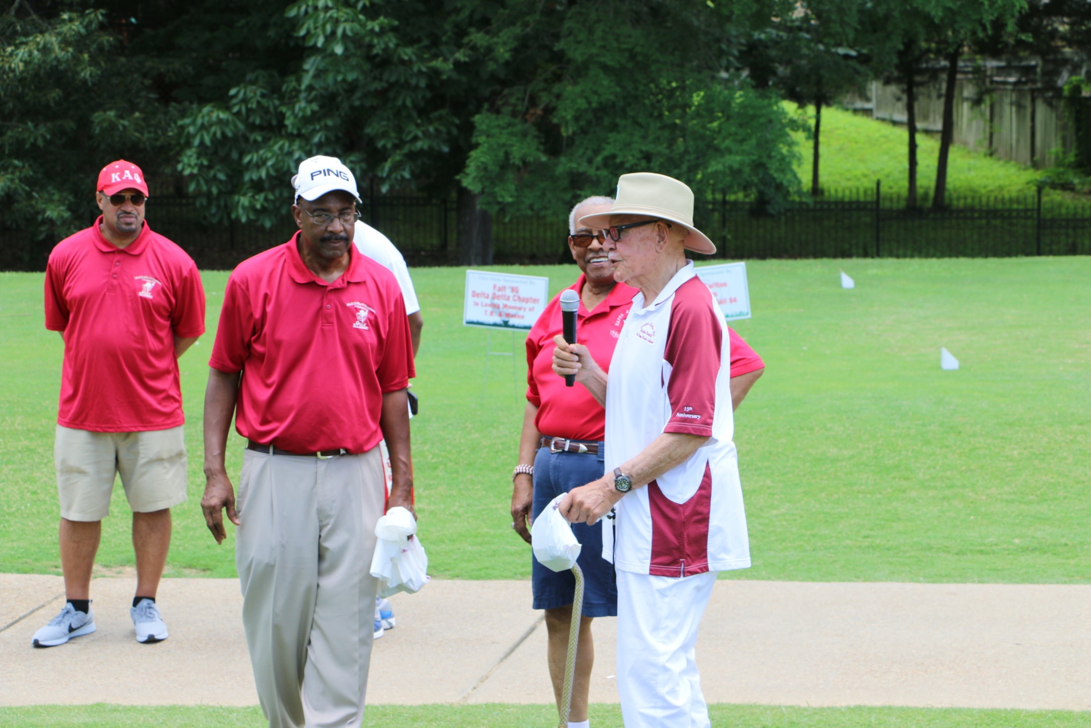 Brother speaking at microphone on the course at Golf Klassic