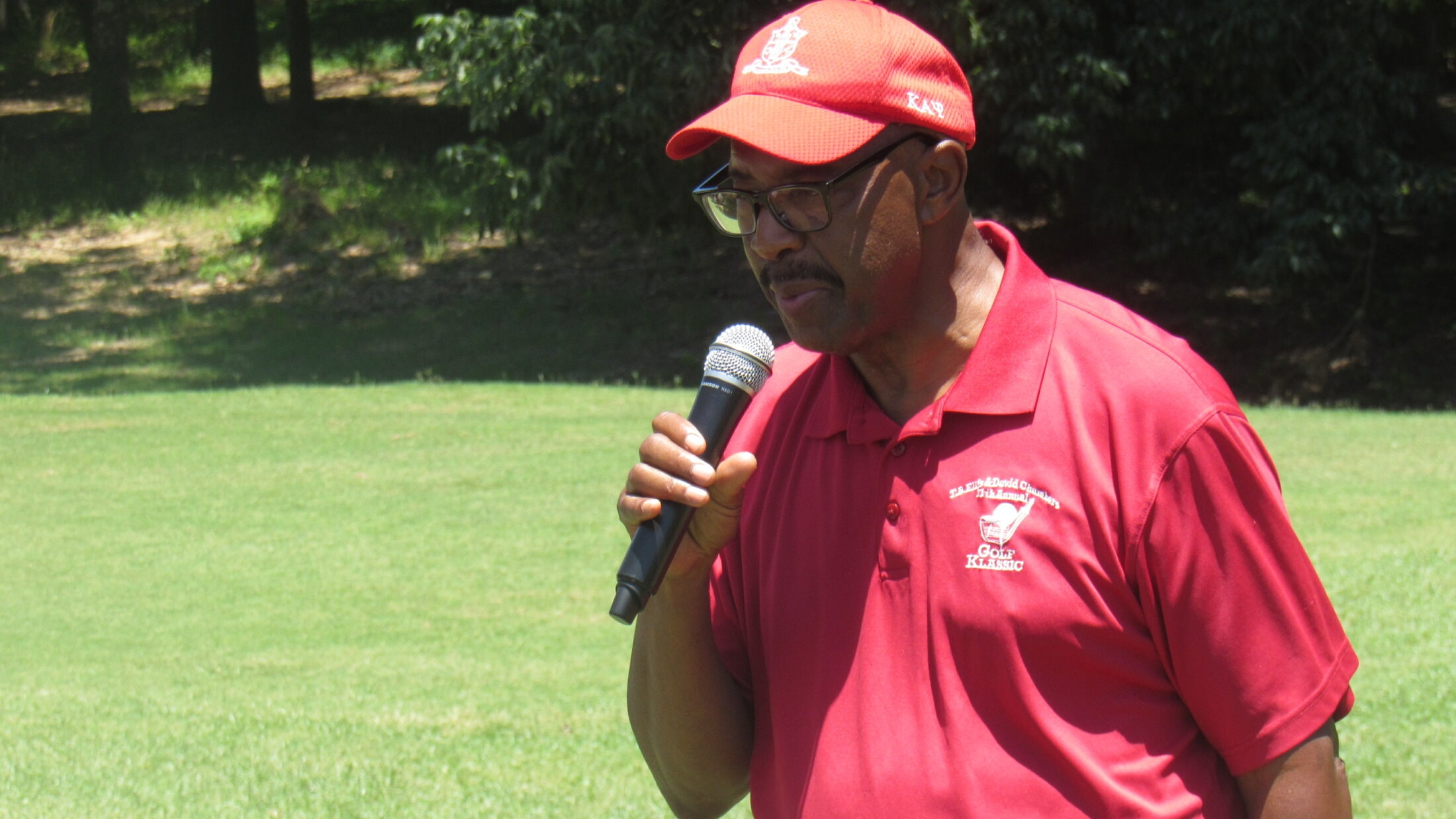 Brother at podium with Kappa Alpha Psi cap at Golf Klassic
