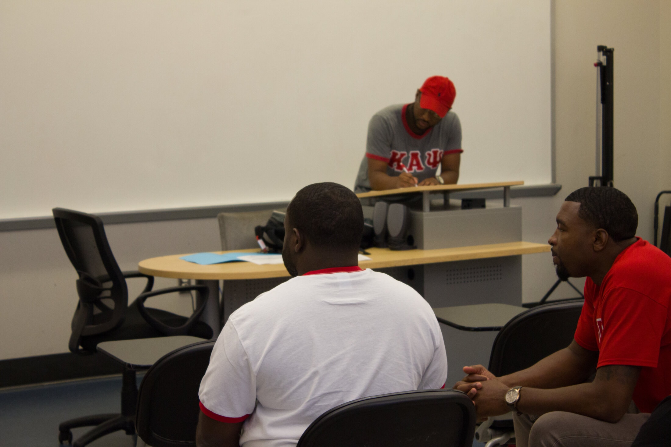 Three brothers in classroom committee room setting