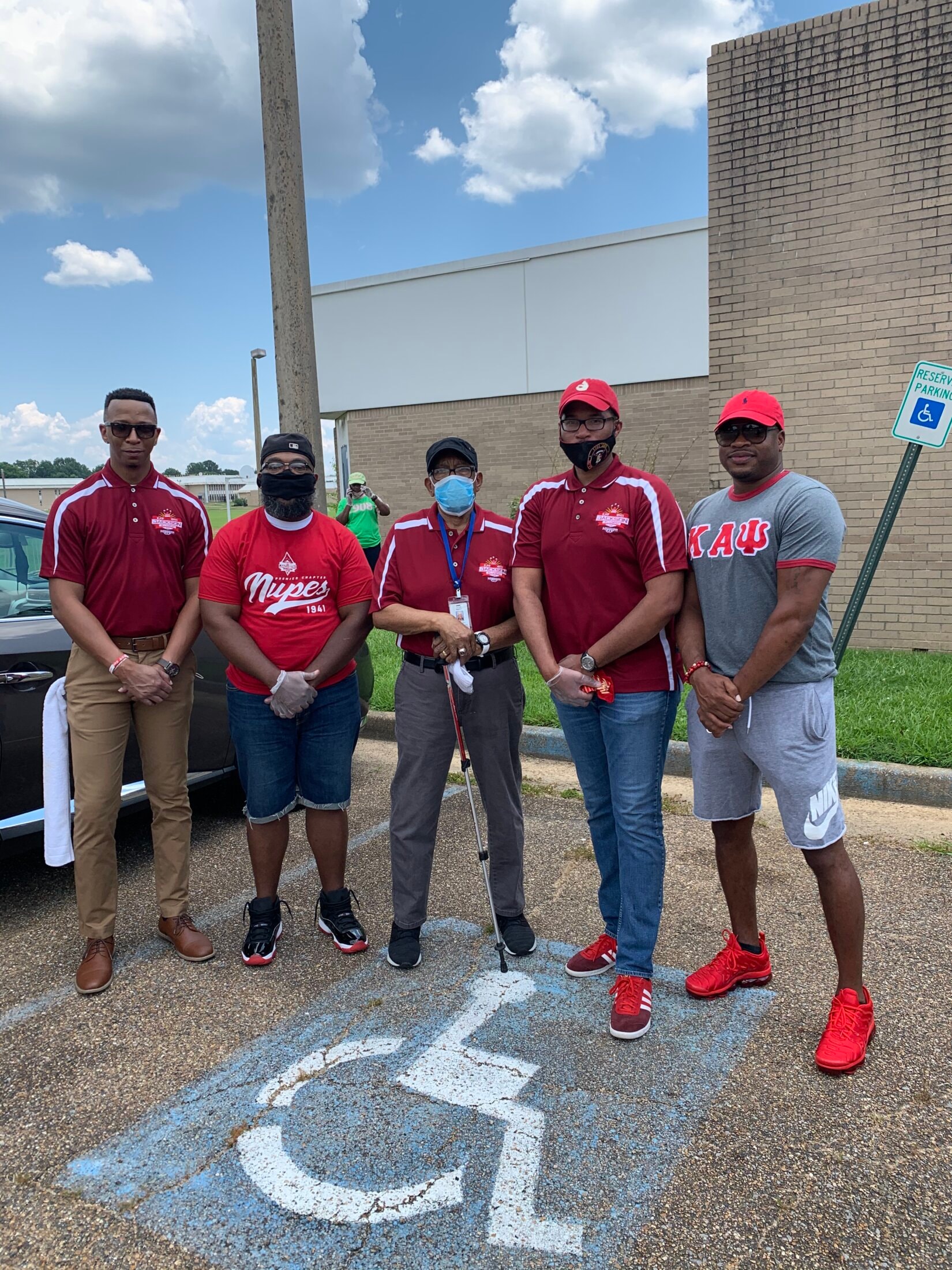 Brothers in Kappa Alpha Psi gear at masked outdoor community event