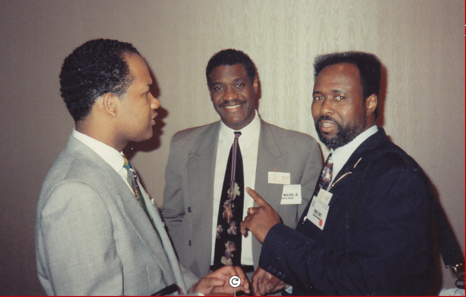 Three brothers in business suits at professional conference event